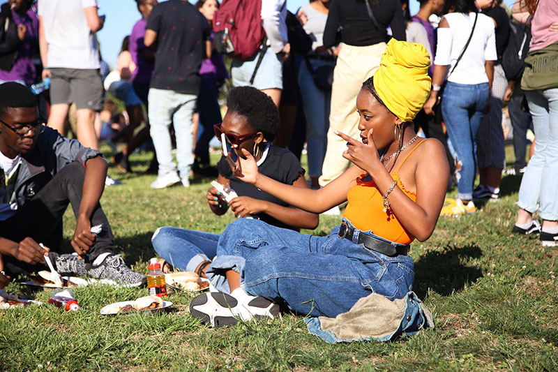 Group of student relaxing and having lunch seated on the ground